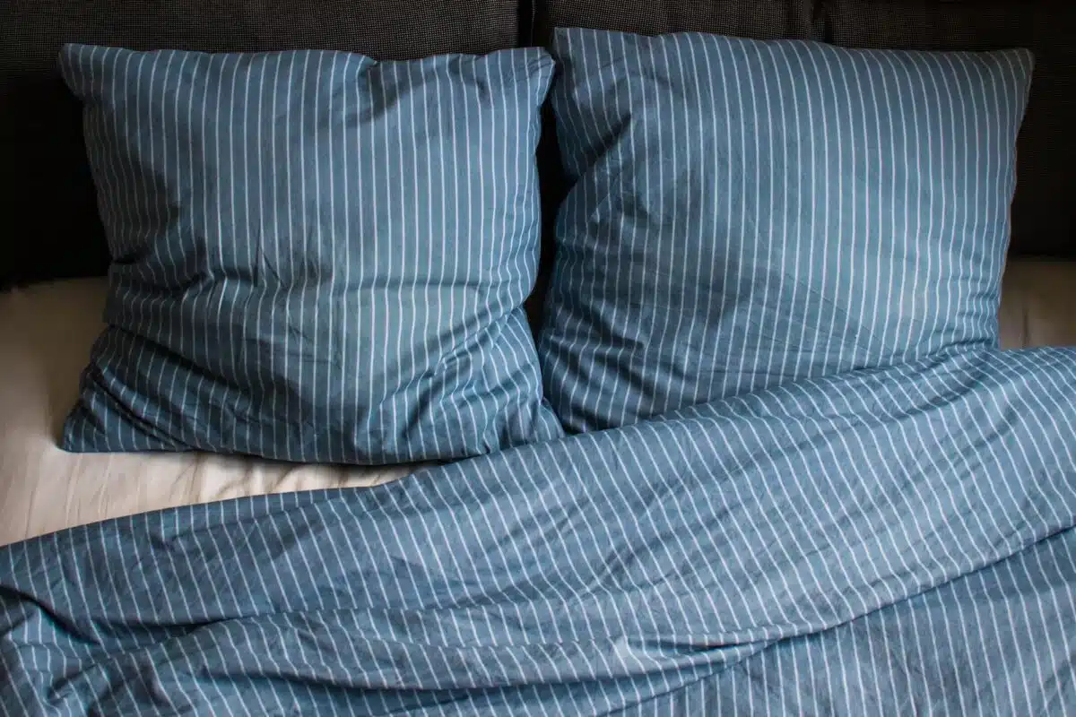 a bed with two pillows and a blanket on top of it