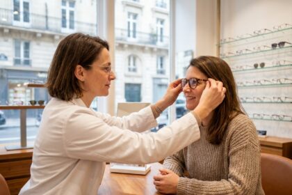 Opticienne professionnelle aidant une cliente à choisir des lunettes dans une boutique d'optique moderne à Paris
